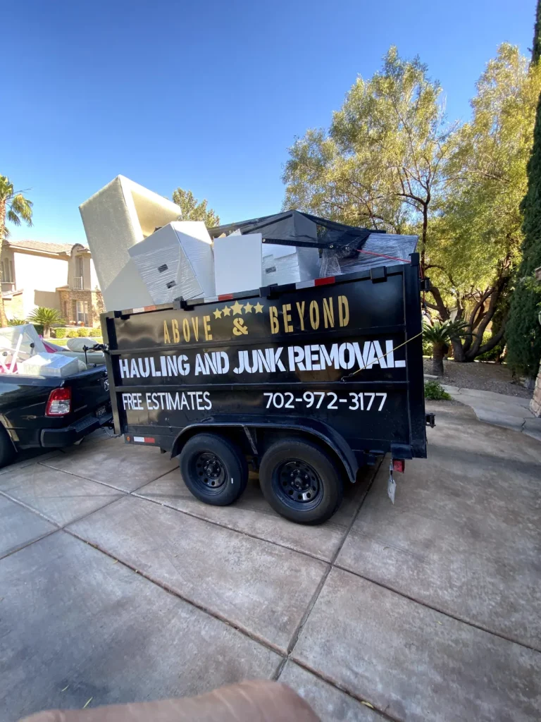 Above & Beyond dump trailer loaded with furniture in a residential driveway