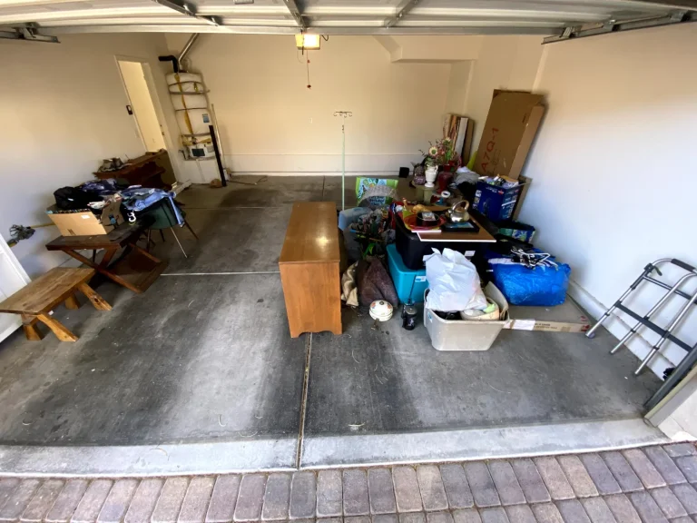 Two-car garage full of furniture, bins and boxes before a junk removal cleanout