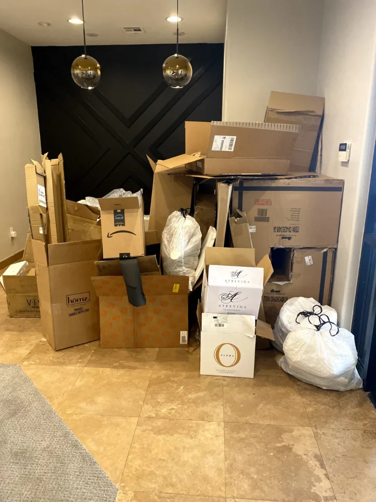 Room stacked with moving boxes and bags before junk removal