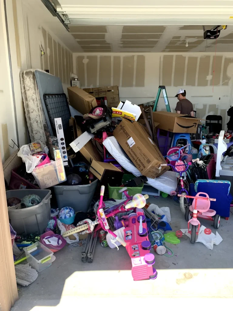 Garage packed with toys, bikes, bins and household clutter awaiting junk removal