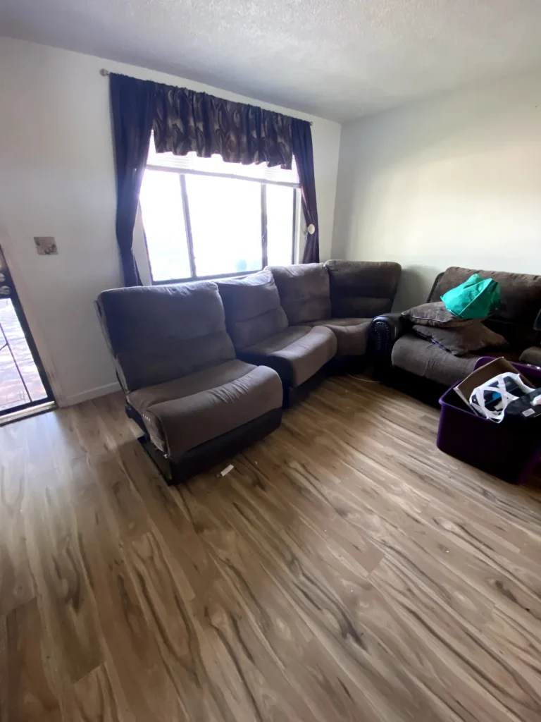 Gray sectional couch in a living room ready for furniture removal