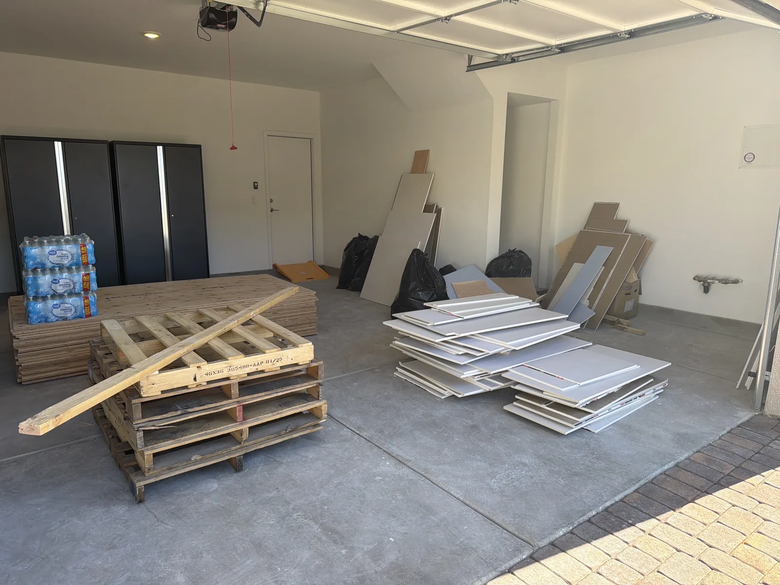 Construction debris removal Las Vegas — drywall, plywood and pallets in a garage