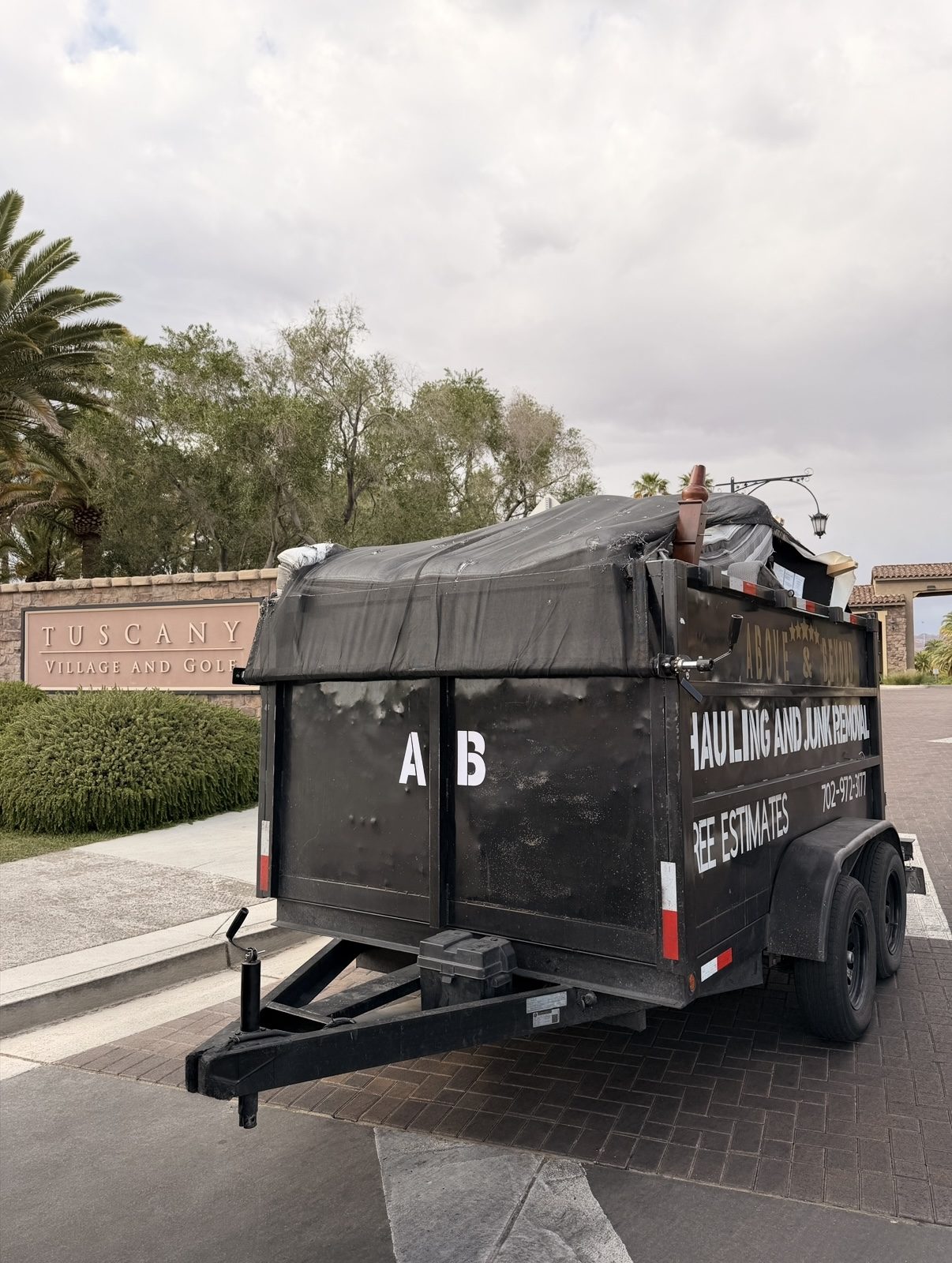 Above & Beyond Hauling and Junk Removal dump trailer loaded with junk at Tuscany Village in Henderson, NV